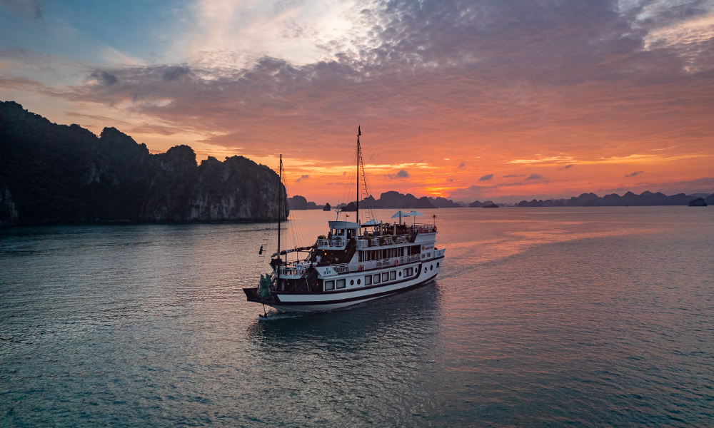 Sunset over Bai Tu Long Bay with Dragon Pearl Junk.